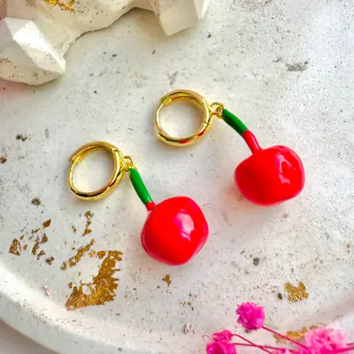 Aretes de argolla dorada con cereza roja colgante