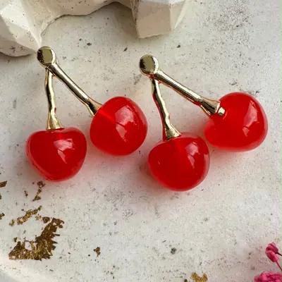 Aretes con dos cerezas rojas colgantes