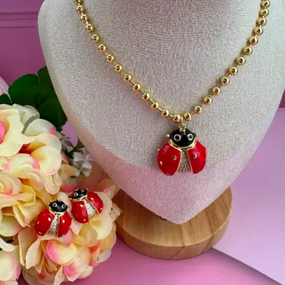 Conjunto de collar y aretes con mariquitas rojas