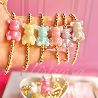 Pulsera de bolas doradas con dije de oso en acabado tornasol