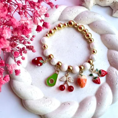 Pulsera encauchada en polvo de nacar y dijes colgantes de rodio, balines #6 y #8 en rodio